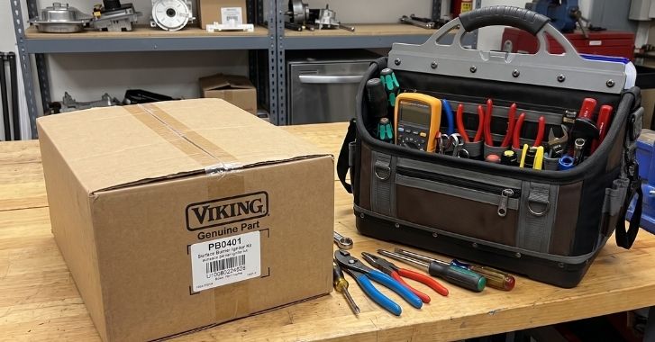 Genuine Viking replacement part in original packaging beside a technician's tools